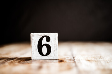 6 - Number 6 - Number Six - White block with number on wooden table and dark background