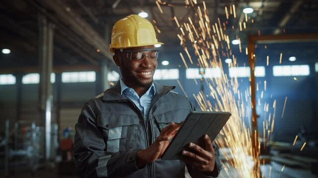 Professional Heavy Industry Engineer/Worker Wearing Safety Uniform and Hard Hat Uses Tablet Computer