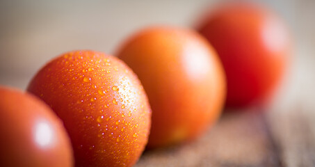 Red ripe tomatoes in line on wooden background