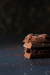 Stack of dark chocolate with cacao powder.