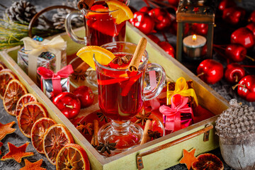 christmas mulled wine with oranges, cinnamon and star anise on the tray, decoration with gift boxes