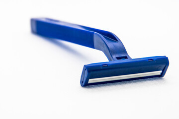On a white background, a blue razor. The background is blurred.