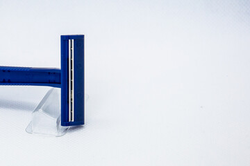 On a white background the head of a blue razor with a blade.