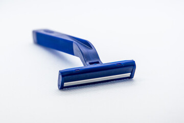 On a white background, a blue razor. The background is blurred.