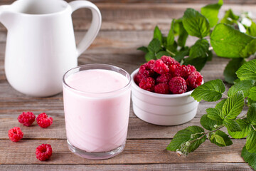 Homemade yoghurt in a glass glass with organic raspberries. Healthy and dietary food