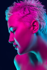 Passion. Portrait of female fashion model in neon light on dark studio background. Beautiful caucasian woman with trendy make-up and well-kept skin. Vivid style, beauty concept. Close up. Copyspace