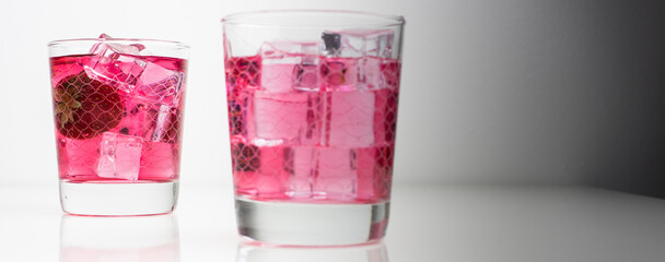 Fresh berries and vodka in a glass on white background