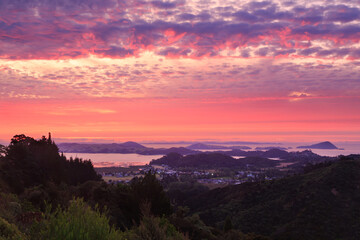 Fototapeta na wymiar A view of Coromandel, a seaside town on the Coromandel Peninsula, New Zealand, at sunset, taken from the surrounding mountains