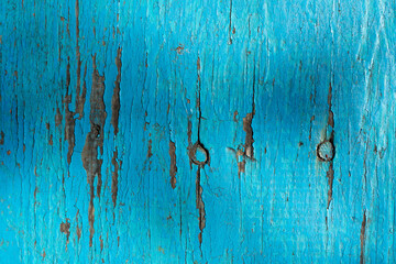 Horizontal pattern of grunge blue wall with scratches, cracks and peeling paint