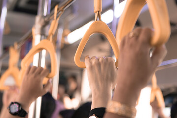 People hand holding handle on the bus gate. Donmuang, Bangkok, Thailand, Asia