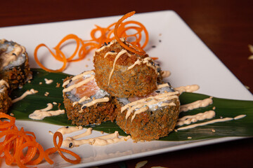 Close-up of a plate of tempura Maki with cheese, onions and salmon. Isolated image