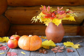 Pumpkin, apples, and autumn foliage on wooden background. Thanksgiving Day. 