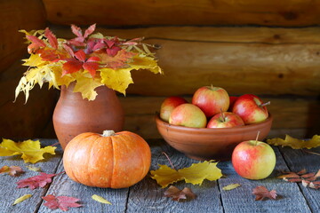 Naklejka na ściany i meble Pumpkin, apples, and autumn foliage on wooden background. Thanksgiving Day. 