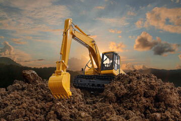 Excavators are digging the soil in the construction site on the  sunset  background