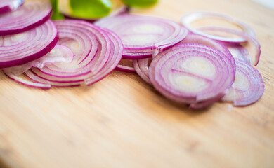 Obraz na płótnie Canvas Red onion slices isolated on wooden chopping board