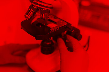 Duotone color of Young female Laboratory scientist working at lab with test tubes and microscope,...