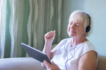 elderly woman listening to music with headphones, talking on the phone