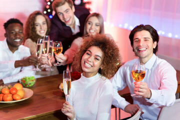 Cheerful Friends Having New Year Dinner Holding Glasses At Home