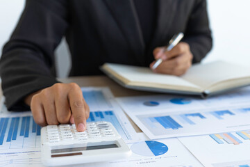 The Asian female finance staff is pressing a calculator to check the Company's financial investment results. To summarize and prepare to report the results to the meeting, Concepts of calculation