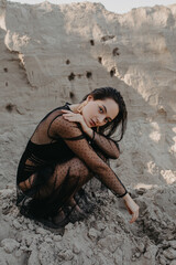Pretty woman poses in sand quarry.