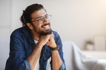 Portrait Of Smiling Indian Man With Eyeglasses And Braces In Home Interior