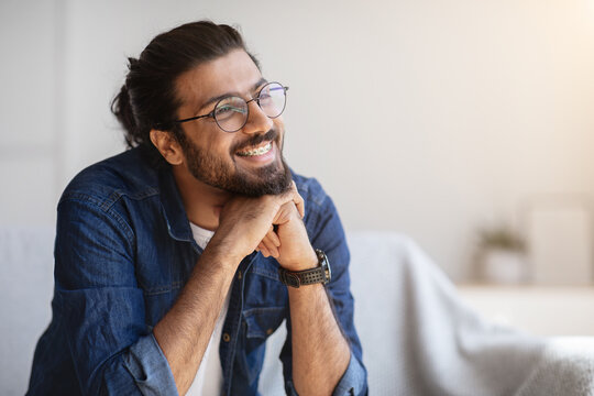 Portrait Of Smiling Indian Man With Eyeglasses And Braces In Home Interior