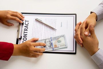 bribery and corruption concept, businesswoman offer bribes to businessman to sign and manage real estate contracts smoothly.