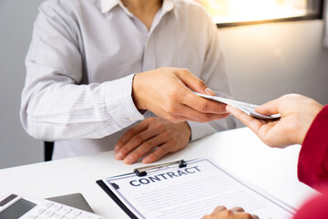 bribery and corruption concept, businessmen offer bribes to business women to sign and manage real estate contracts smoothly.
