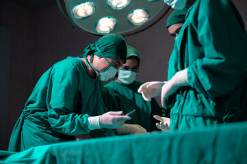 Medical team performing surgical operation, operating room staff doctors surgeons nurses assisting performing doing surgery surgical procedure in operating room