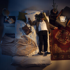 Nightmare. Portrait of a businessman, accountant sleeping in the bed at home. Top view. Dressed office worker, financist sleeping after tiring wotk day. Holding his case close to. Workaholic. Job.