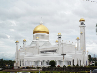 Fototapeta na wymiar Bandar Seri Begawan, Brunei, January 25, 2017: White facade and golden domes of the Sultan Omar Ali Saifuddin Mosque in Brunei