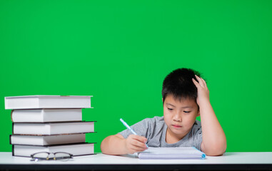 Student doing homework on green screen, child writing paper, education concept, back to school
