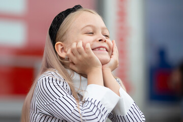 Fototapeta Funny little blonde girl smiles beautifully. A rado child. obraz