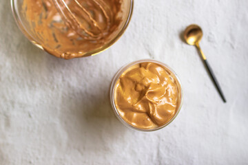 Dalgona Coffee; fluffy whipped coffee on milk. Coffee is a beverage made by whipping equal proportions of instant coffee, sugar and hot water until it becomes creamy. Top view