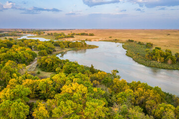 shallow and wide Dismal River flowing through Nebraska Sandhills at Nebraska National Forest, aerial view of afternoon scenery in early fall