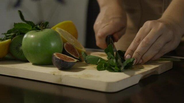 Woman slicing mint on the table
