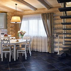 Country style kitchen interior with wooden rustic furniture and elegant lampshade over dining table in modern village house with wide curtained window