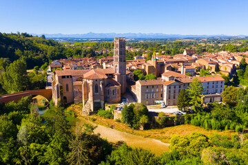 Scenic aerial view of Rieux-Volvestre town on banks of small tributary of Garonne in summer...