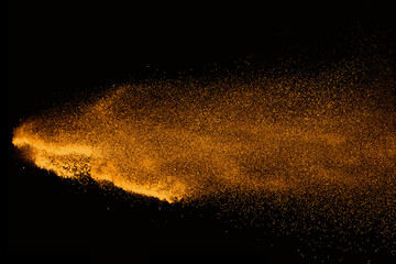 Fototapeta na wymiar Abstract orange powder explosion isolated on black background.