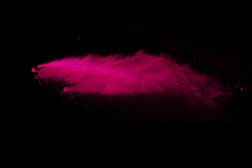 Pink powder explosion on black background. Colored cloud. Colorful dust explode. Paint Holi.