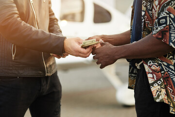 Cropped shot view of two man counting America dollars money in her hands.