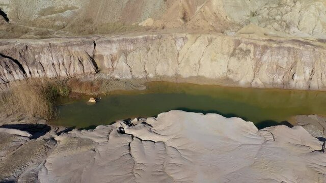 Aerial view of abandoned and flooded open pit gypsum mine, quarry, polluted pond