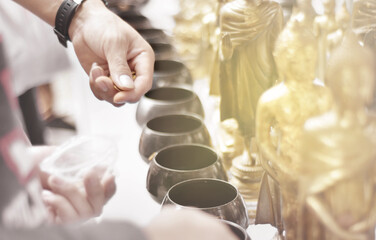 Belief, Faith and donate concept. Buddhists in making merit and exorcise with made to donate little money in small monks bowls according to religious beliefs. Selective focus.