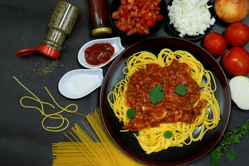 Tasty appetizing classic italian spaghetti pasta with tomato sauce, cheese parmesan and basil on plate on dark table. ,Select Focus