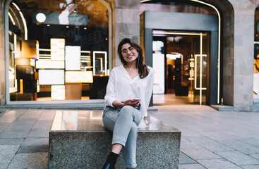 Positive woman listening to music on sidewalk