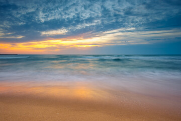 Fototapeta na wymiar Beach sunrise over the sea and dramatic sea