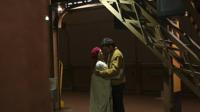 Loving couple observing night city from tower