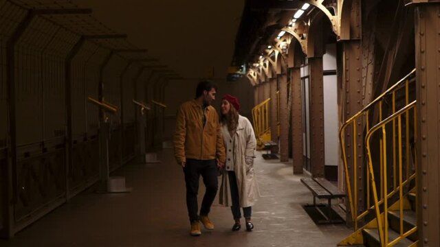 Loving couple observing night city from tower