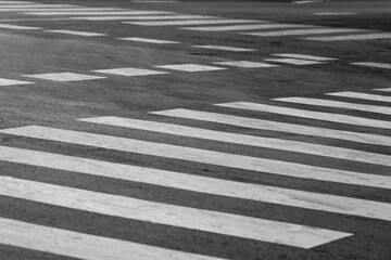 Zebra crossing on intersection, white stripes on asphalt pedestrian, crosswalk for across the road safely, monochrome.