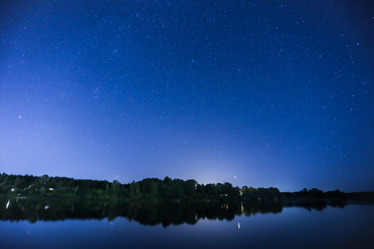 Night sky with stars. Milky way in a sky in front of large river. Landscape photography. 